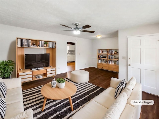 living room featuring hardwood / wood-style floors and ceiling fan