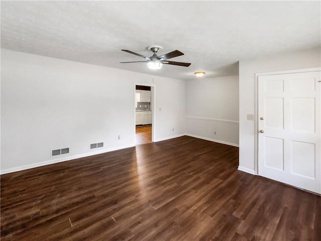 empty room with ceiling fan and dark wood-type flooring