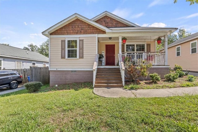 bungalow featuring covered porch and a front yard