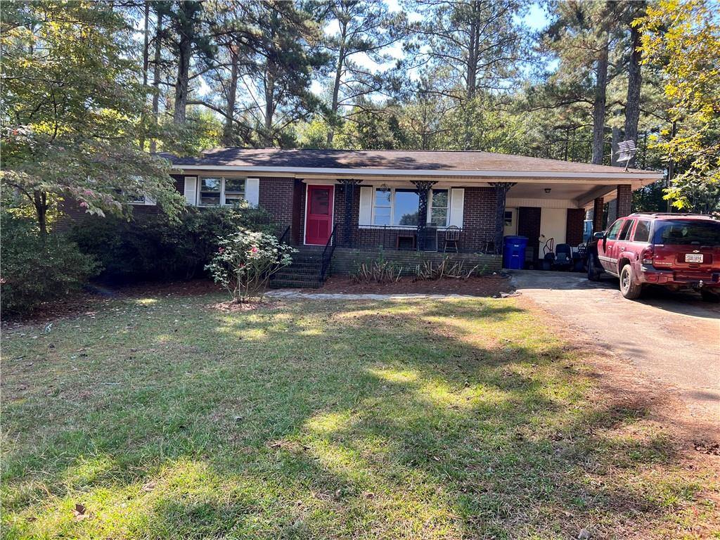 single story home featuring a carport and a front yard