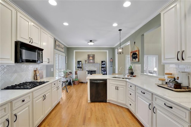 kitchen featuring crown molding, black appliances, white cabinets, and pendant lighting