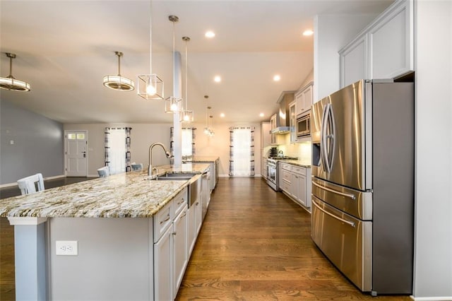 kitchen with pendant lighting, a spacious island, dark wood-type flooring, appliances with stainless steel finishes, and white cabinets