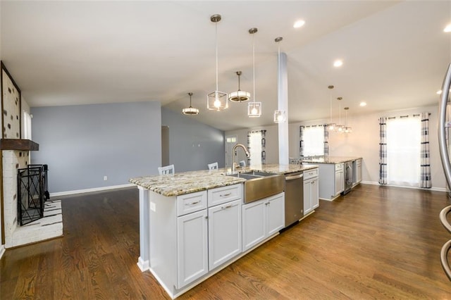 kitchen featuring dishwasher, a fireplace, decorative light fixtures, white cabinetry, and sink