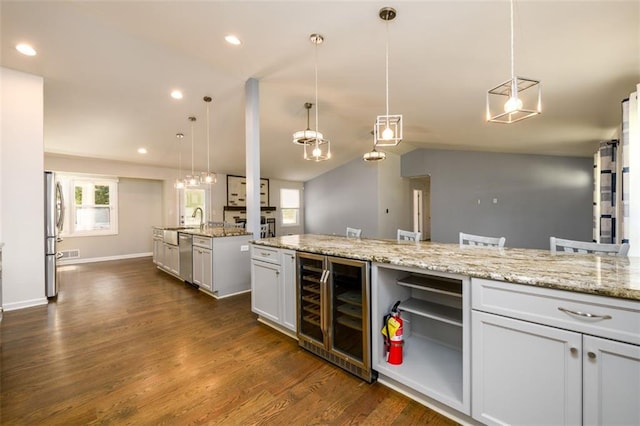 kitchen with decorative light fixtures, wine cooler, and white cabinetry