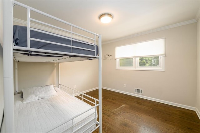 unfurnished bedroom with ornamental molding and dark hardwood / wood-style floors