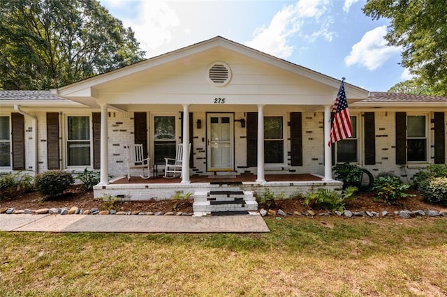 ranch-style house featuring a front lawn and covered porch