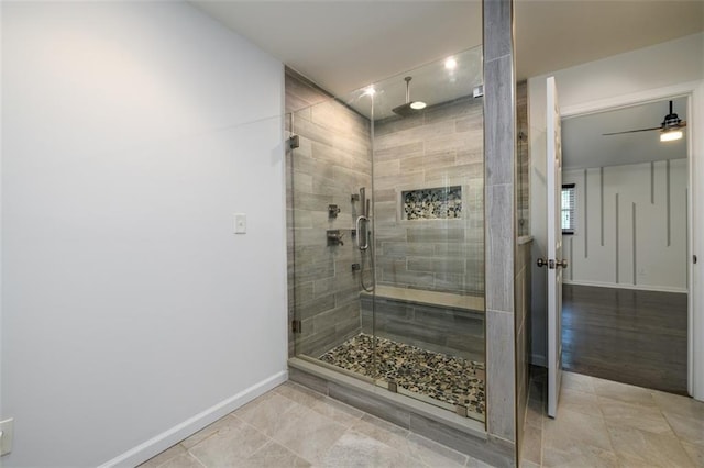 bathroom featuring ceiling fan, a shower with door, and hardwood / wood-style flooring