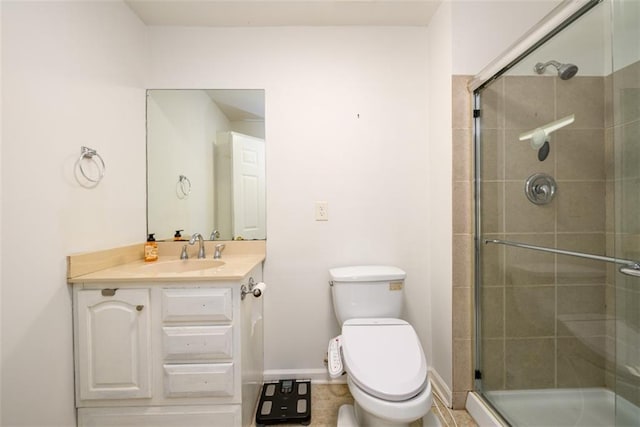 bathroom with vanity, toilet, and a shower with door