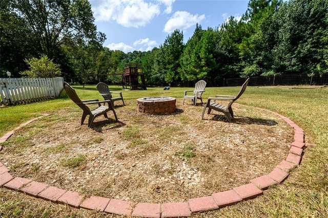 view of yard featuring a playground and an outdoor fire pit