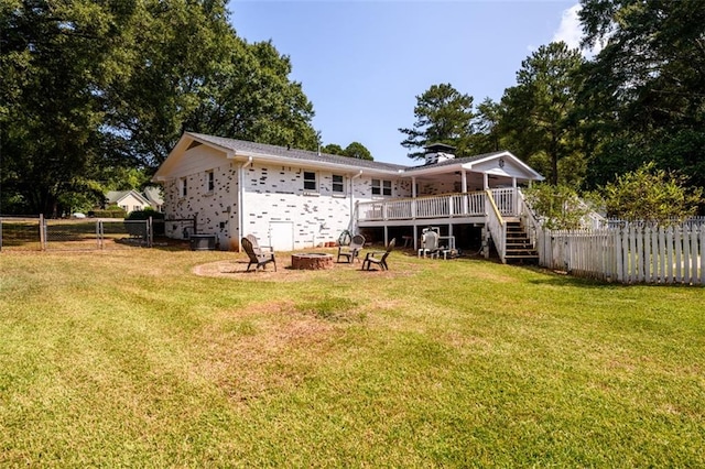 back of property featuring a yard and a wooden deck