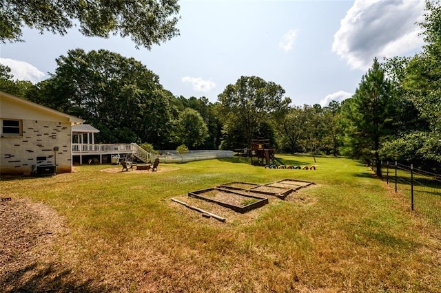 view of yard with a deck and a playground