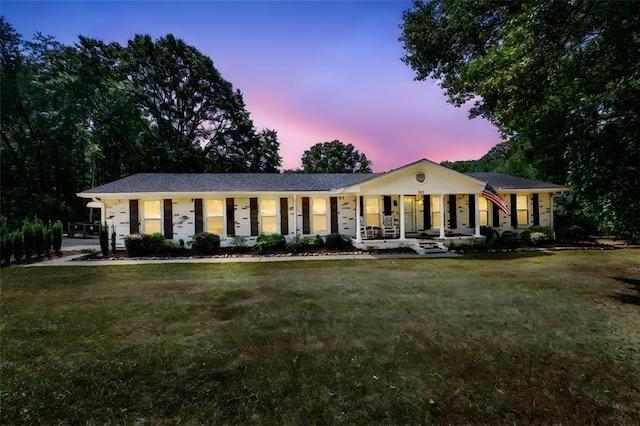 ranch-style home featuring a porch and a yard