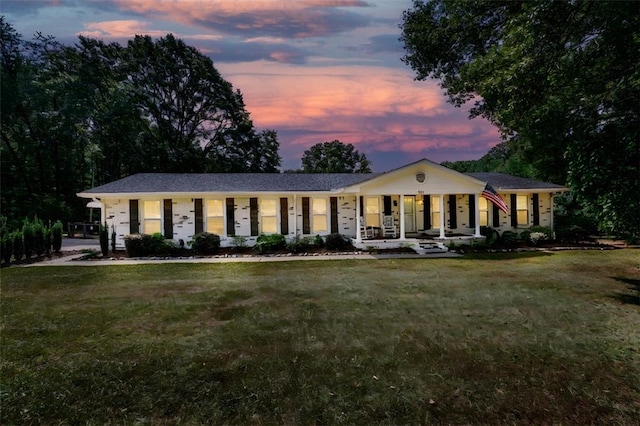 ranch-style home featuring a yard and covered porch