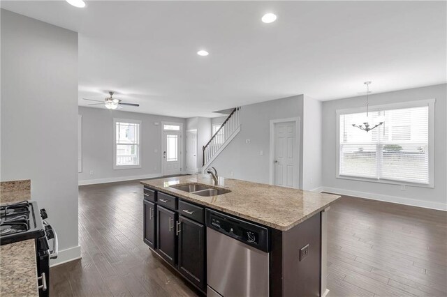 kitchen featuring a sink, dishwasher, black gas stove, open floor plan, and baseboards