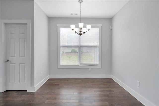 unfurnished dining area with a chandelier, baseboards, and dark wood-style flooring
