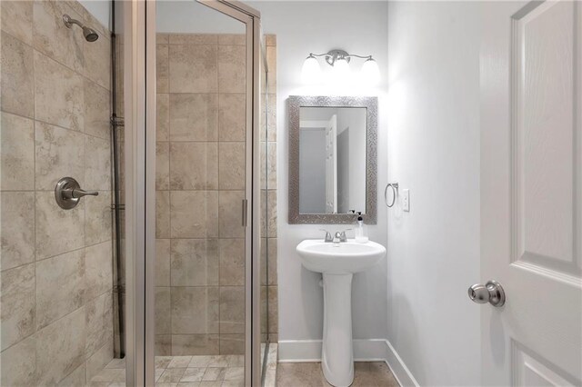 bathroom with a stall shower and a sink
