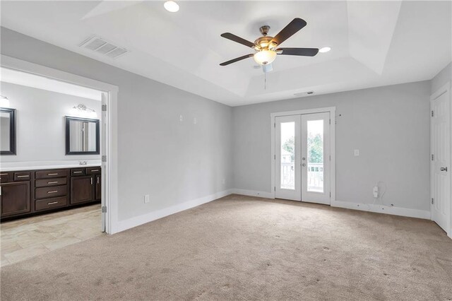 unfurnished bedroom featuring a raised ceiling, access to outside, light carpet, baseboards, and recessed lighting