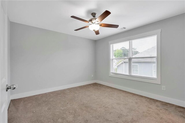 spare room with carpet flooring, a ceiling fan, and baseboards