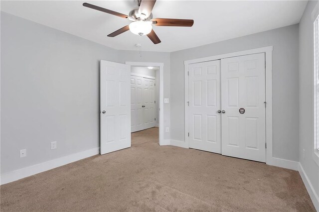 unfurnished bedroom with carpet floors, baseboards, a closet, and ceiling fan