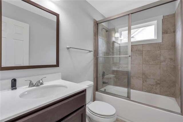 full bath with vanity, toilet, and enclosed tub / shower combo