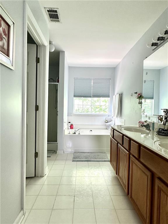627 Arbour Way, Suwanee, GA 30024 - bathroom with a garden tub, double vanity, a stall shower, and tile patterned floors