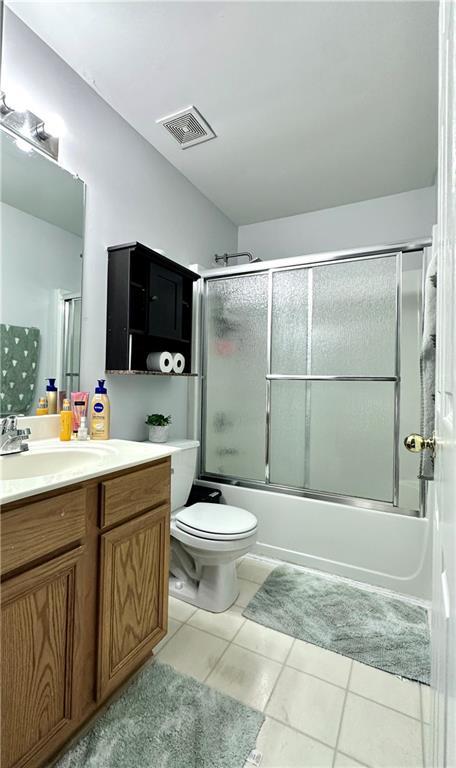 627 Arbour Way, Suwanee, GA 30024 - full bath featuring vanity, shower / bath combination with glass door, toilet, and tile patterned flooring