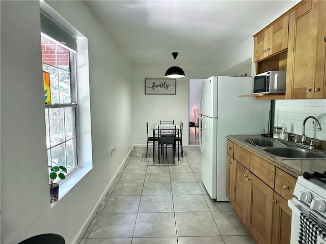 627 Arbour Way, Suwanee, GA 30024 - kitchen with white appliances, a sink, brown cabinetry, light tile patterned floors, and baseboards
