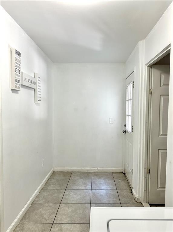 627 Arbour Way, Suwanee, GA 30024 - empty room featuring light tile patterned floors and baseboards