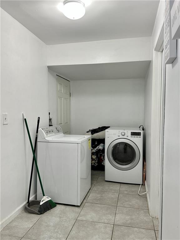 627 Arbour Way, Suwanee, GA 30024 - washroom with washer and dryer and light tile patterned flooring