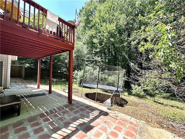 627 Arbour Way, Suwanee, GA 30024 - fenced backyard with a trampoline, a patio area, and a deck