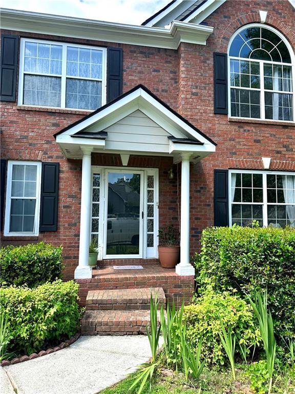 627 Arbour Way, Suwanee, GA 30024 - view of exterior entry featuring brick siding