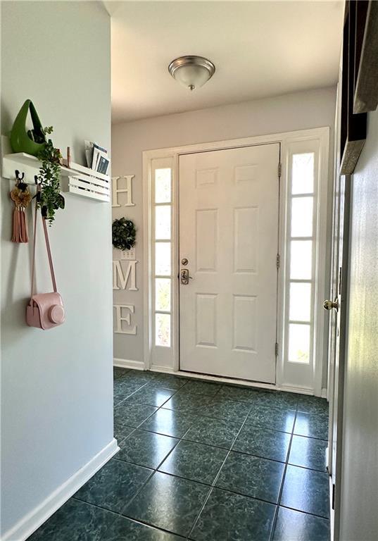 627 Arbour Way, Suwanee, GA 30024 - foyer with plenty of natural light, dark tile patterned floors, and baseboards
