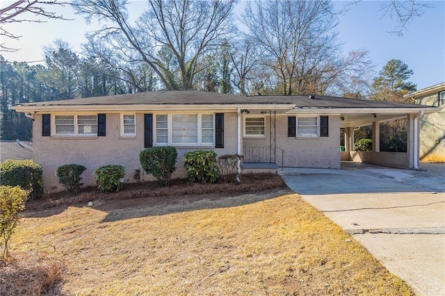 single story home with driveway, a carport, a front lawn, and brick siding