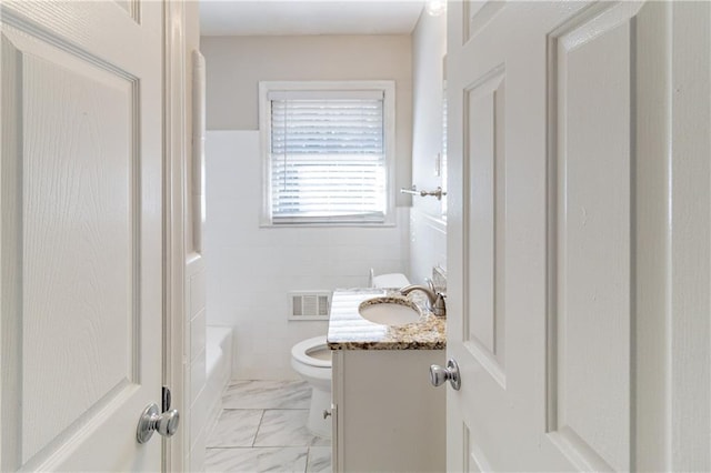 bathroom with marble finish floor, tile walls, visible vents, toilet, and vanity