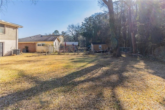 view of yard featuring an outbuilding, a storage unit, and central AC unit