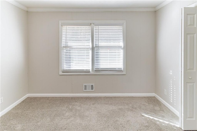 carpeted empty room with baseboards, visible vents, and crown molding