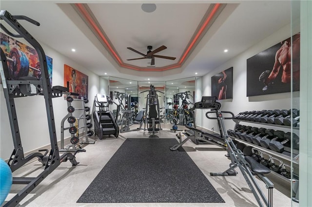 gym with a raised ceiling, a ceiling fan, and recessed lighting