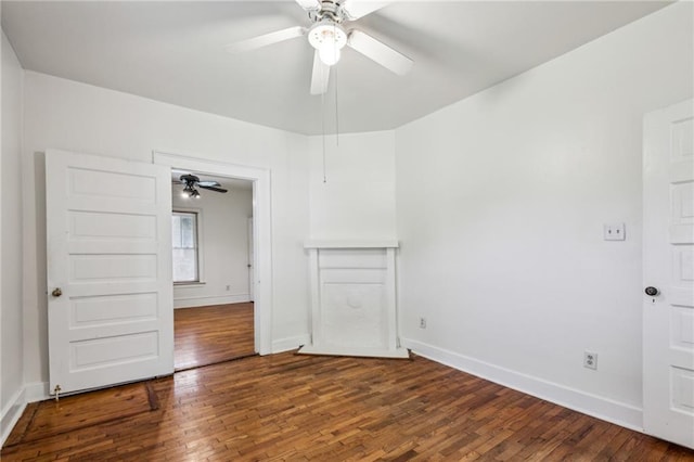 empty room with ceiling fan, wood finished floors, and baseboards