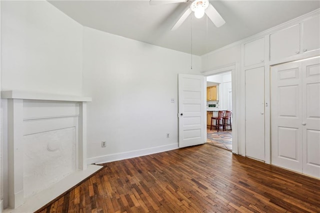 unfurnished bedroom featuring dark wood-type flooring, baseboards, and ceiling fan