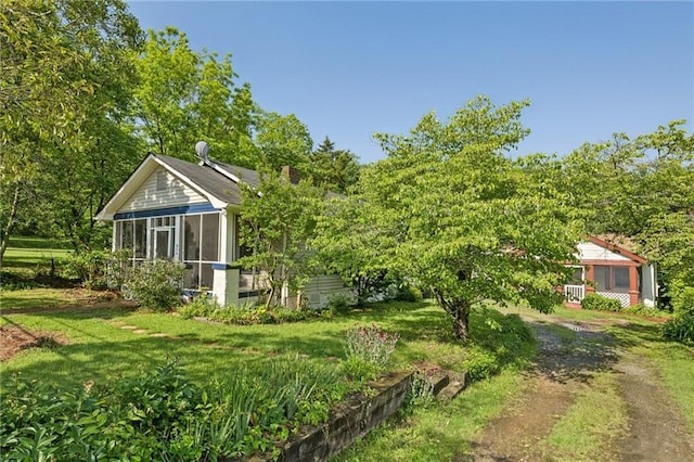 view of green lawn with a sunroom