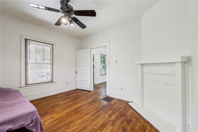 unfurnished bedroom with dark wood-style floors, baseboards, and a ceiling fan