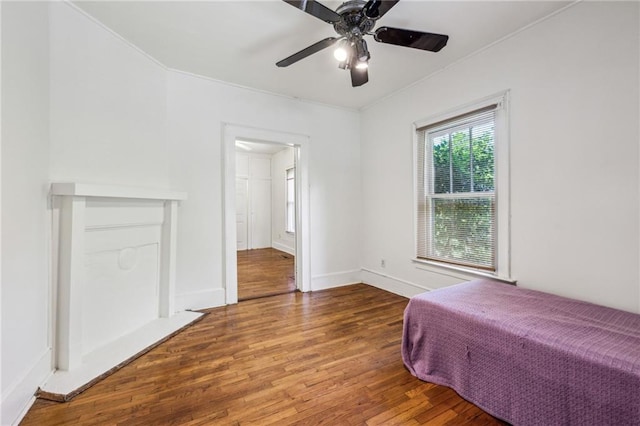 bedroom featuring wood finished floors, baseboards, a ceiling fan, and ornamental molding