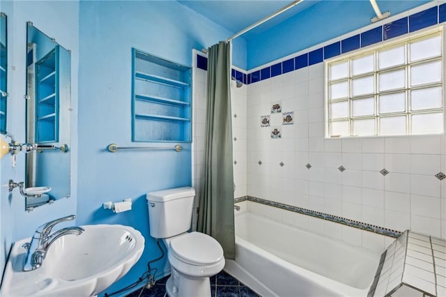 bathroom with a sink, toilet, and shower / bath combo