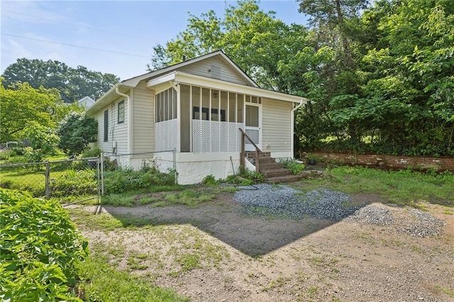 view of front facade featuring fence and a sunroom