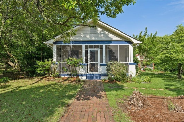 view of front of home with a sunroom and a front yard