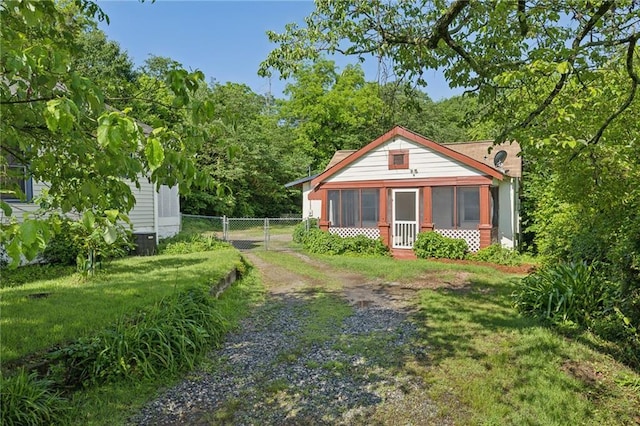 rear view of house featuring a sunroom and driveway