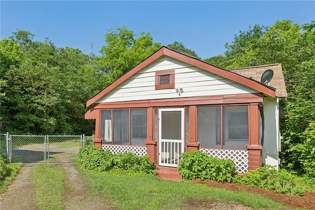 rear view of property with a sunroom, a gate, and fence