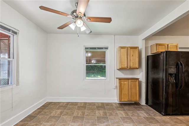 kitchen with black fridge with ice dispenser, healthy amount of natural light, a ceiling fan, and baseboards