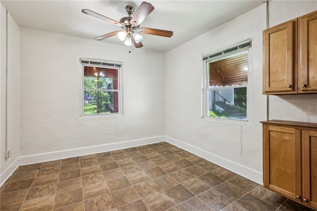 unfurnished room with baseboards and ceiling fan