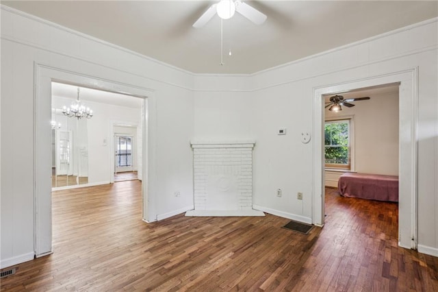 unfurnished room with a ceiling fan, wood finished floors, crown molding, a chandelier, and baseboards